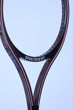 Close-up of the open split-throat design on a black vintage Snauwaert squash racket showing the pre-drilled string holes.