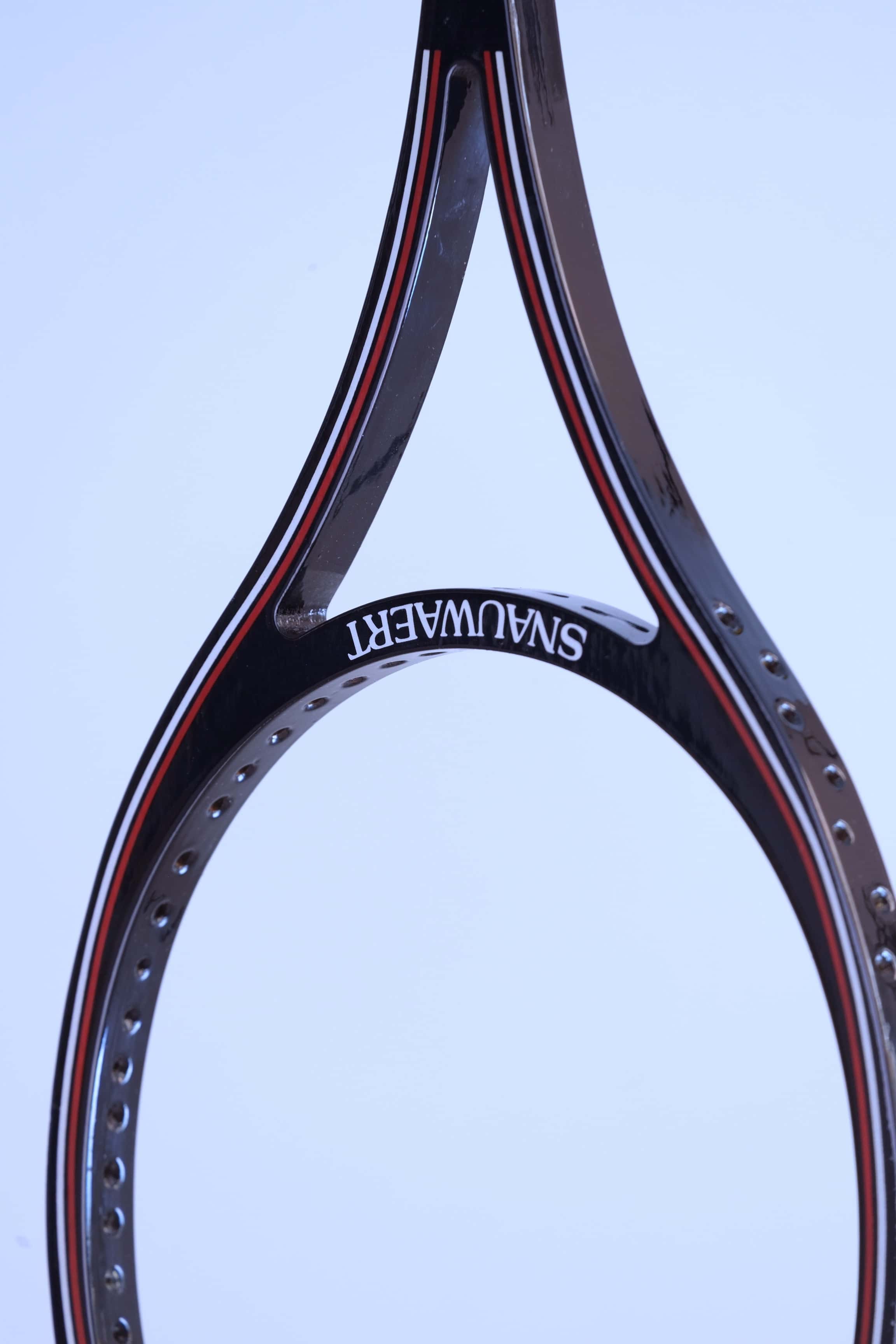 Close-up of the open split-throat design on a black vintage Snauwaert squash racket showing the pre-drilled string holes.