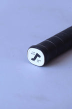Close-up of the white plastic butt cap on a vintage squash racket handle featuring a black Snauwaert logo and the words Your Serve and My Serve.