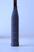 Close-up view of the original black textured leather wrap grip on a vintage squash racket handle.