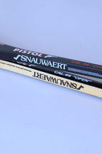 Side-by-side comparison view of the shafts of a glossy black graphite racket and a natural wood grain racket, both displaying Snauwaert branding.