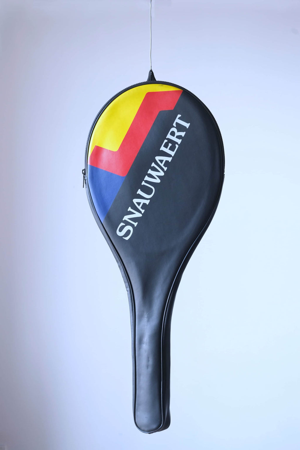 The vintage racquet fully enclosed in its black original cover featuring a bold red, yellow, and blue graphic and white "SNAUWAERT" branding.