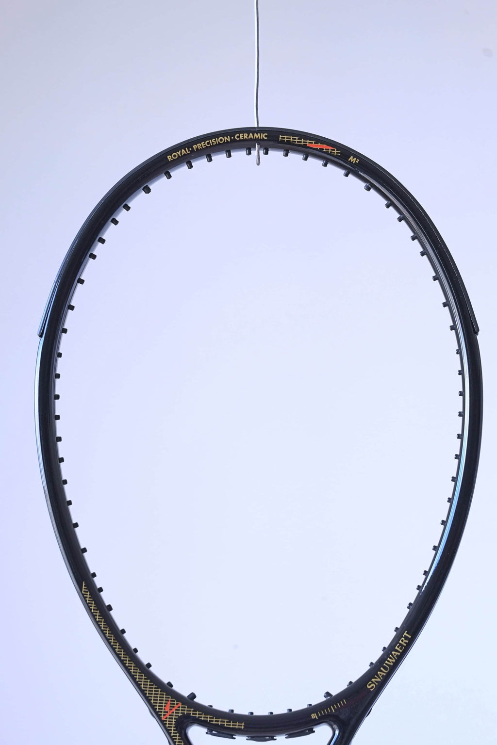 Macro view of the upper racquet hoop featuring the "ROYAL PRECISION • CERAMIC" model name and a red technical graphic.
