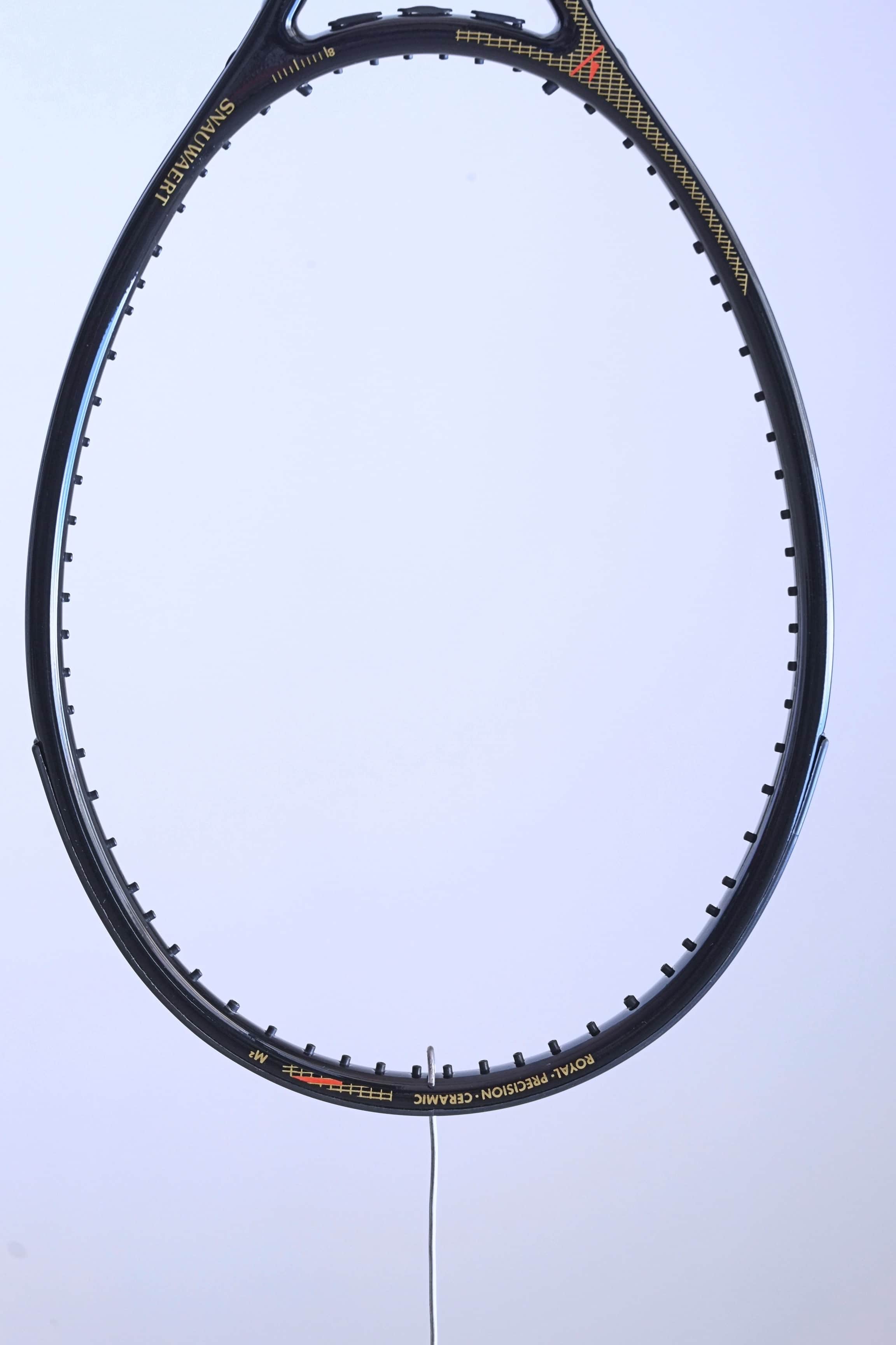 Macro view of the upper racquet hoop featuring the "ROYAL PRECISION • CERAMIC" model name and a red technical graphic.