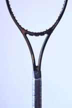 Frontal close-up of the racquet throat showcasing the gold "SNAUWAERT" name, pinstripe detailing.