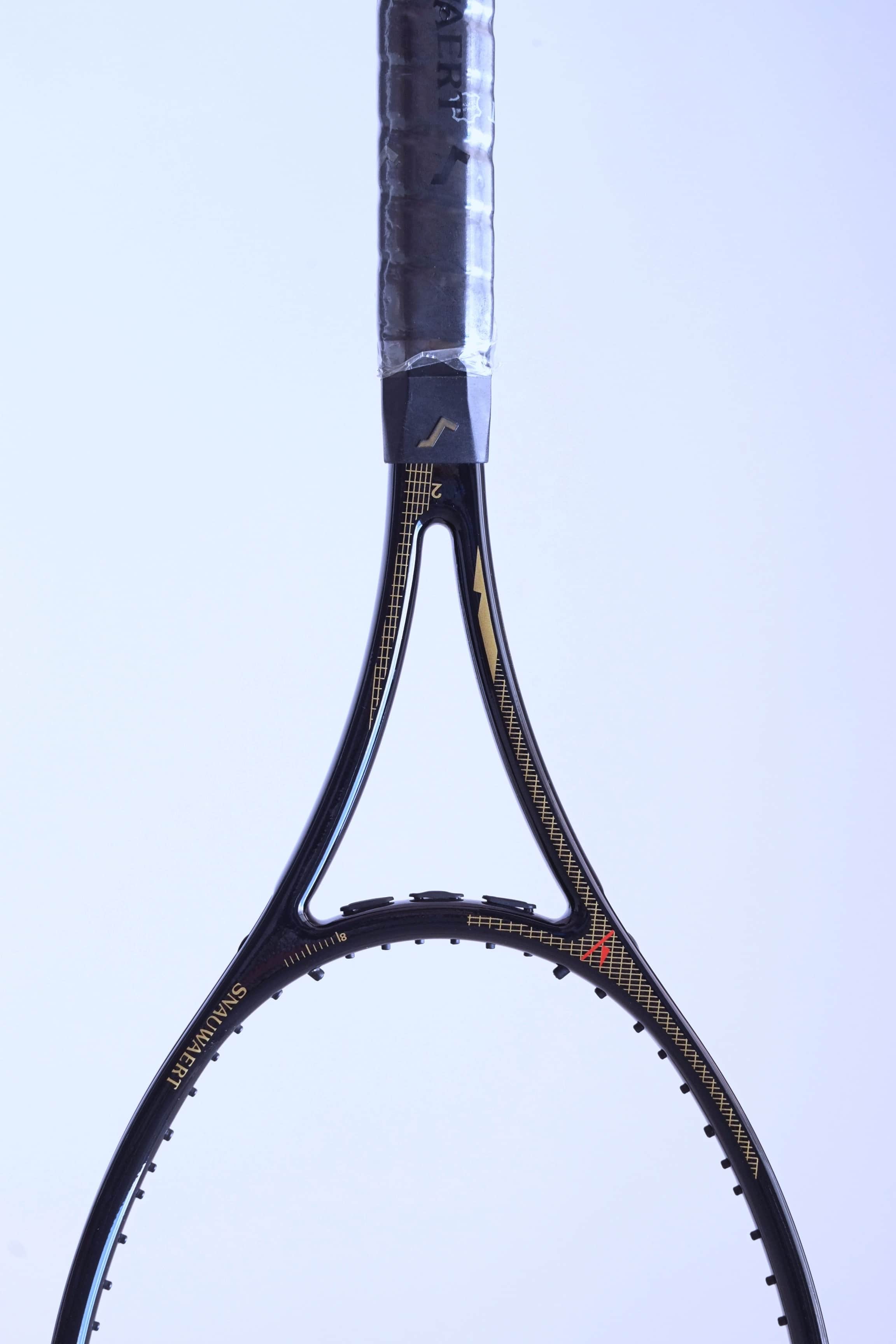 Frontal close-up of the racquet throat showcasing the gold "SNAUWAERT" name, pinstripe detailing.