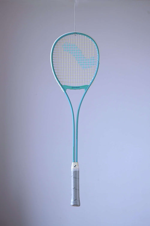 Snauwaert Shark 2 vintage squash racquet suspended against a light background, showing full teal frame, teardrop head and grey branded grip wrap.