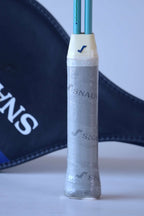 Close-up of the Snauwaert Shark 2 squash racquet grip showing original grey Snauwaert branded wrap, white throat piece and Snauwaert shield cover in background.