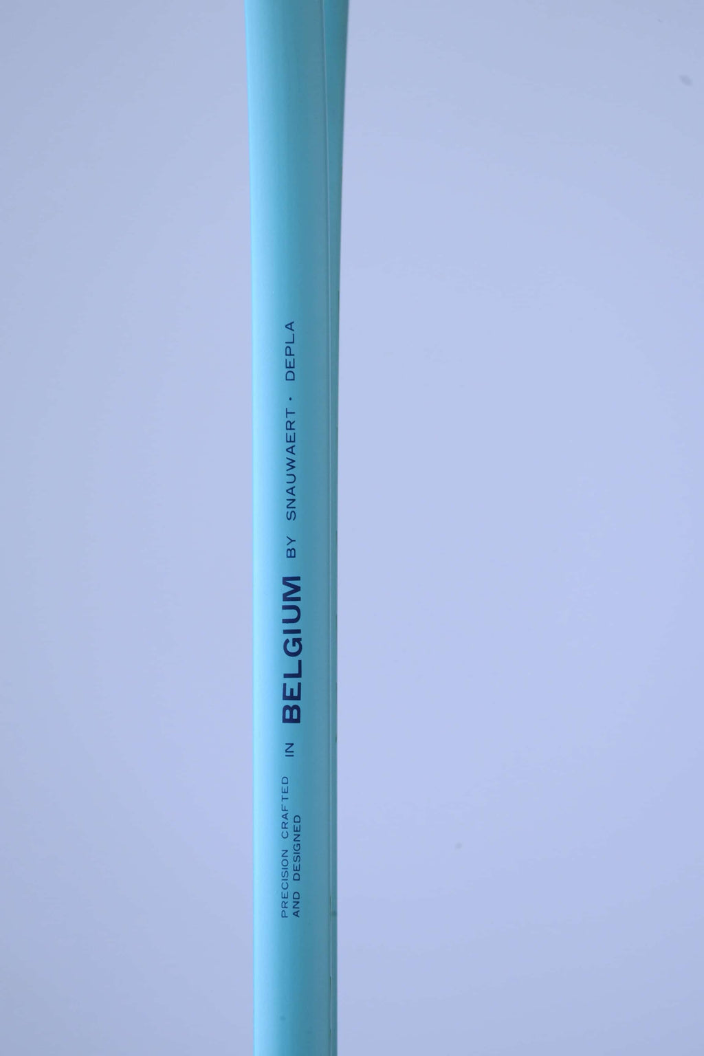 Close-up of the Snauwaert Shark 2 squash racquet shaft showing "Precision Crafted in Belgium by Snauwaert · Depla" text printed on the teal frame.