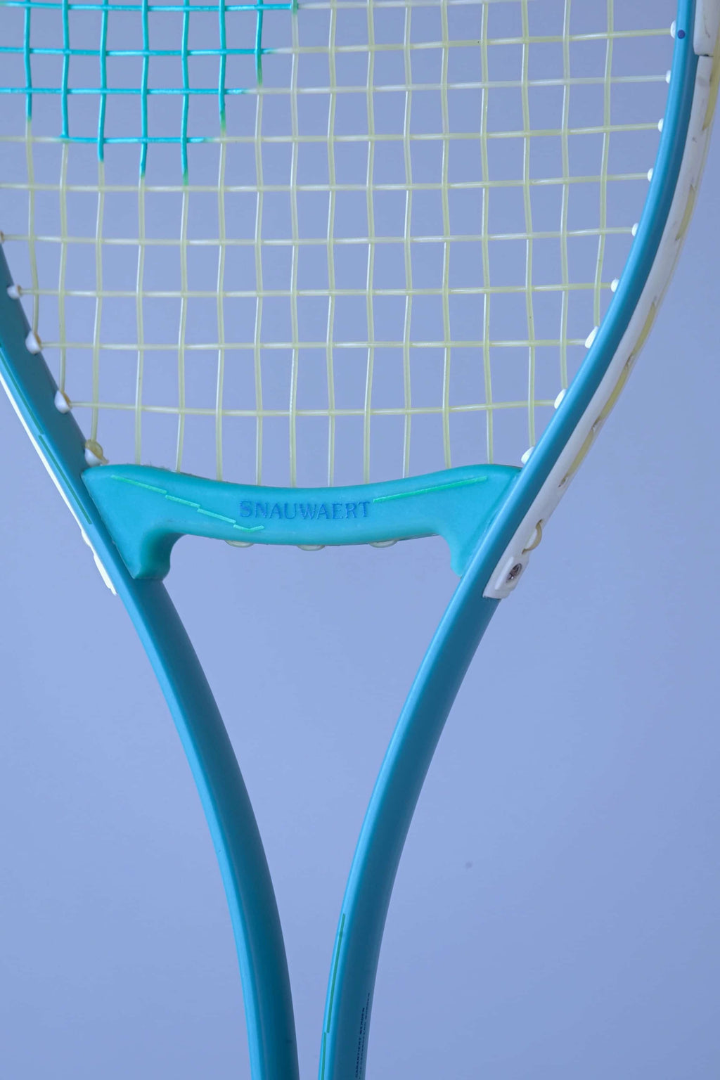 Close-up of the Snauwaert Shark 2 squash racquet throat bridge showing the teal open-throat Y design with Snauwaert branding and white bumper strip detail.