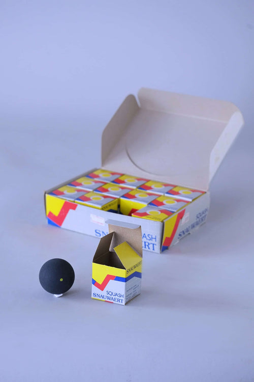 Vintage squash balls arranged inside a box, one of the balls is displayed outside.