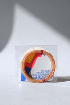 coiled vintage Snauwaert Dynocraft Hi-Ten 25-30 tennis strings in their original grey, yellow, and red and blue retail sleeve packaging.