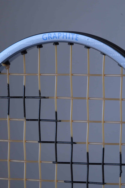 Close-up of a vintage Snauwaert Hi-Ten 25. The word "GRAPHITE" is written in blue along the top edge of the frame. The strings are yellow with part of the black painted logo showing.
