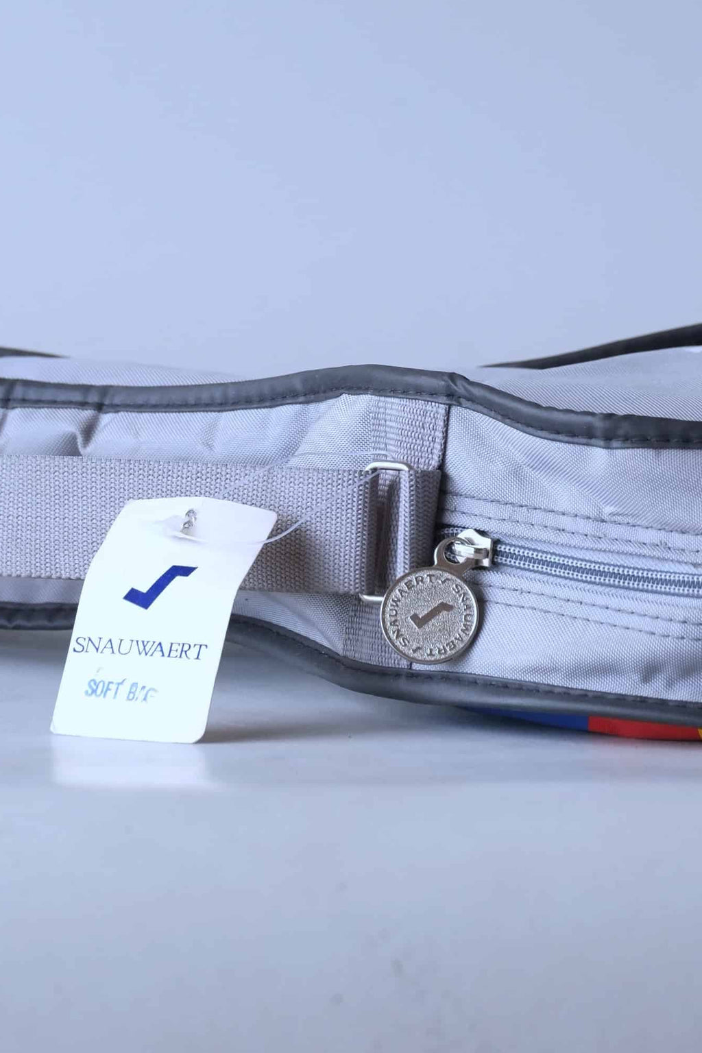 Close-up of the original deadstock white and blue Snauwaert cardboard retail hang-tag and the branded zipper.