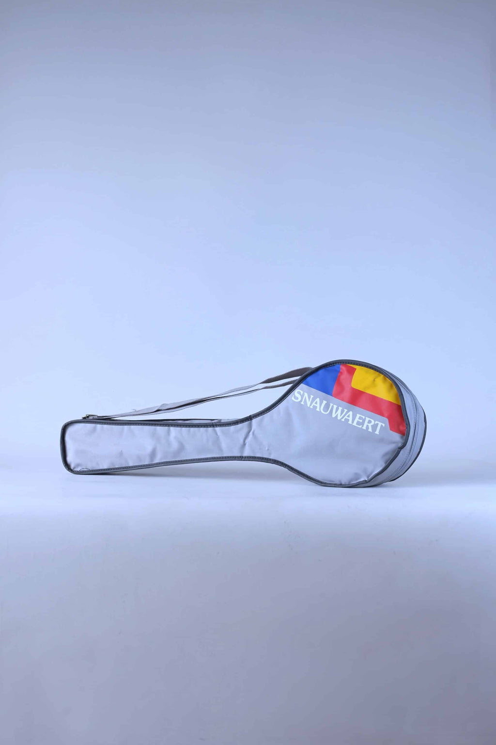 Full view of a vintage grey Snauwaert squash racket soft bag with a shoulder strap and red, yellow and blue brand logo.
