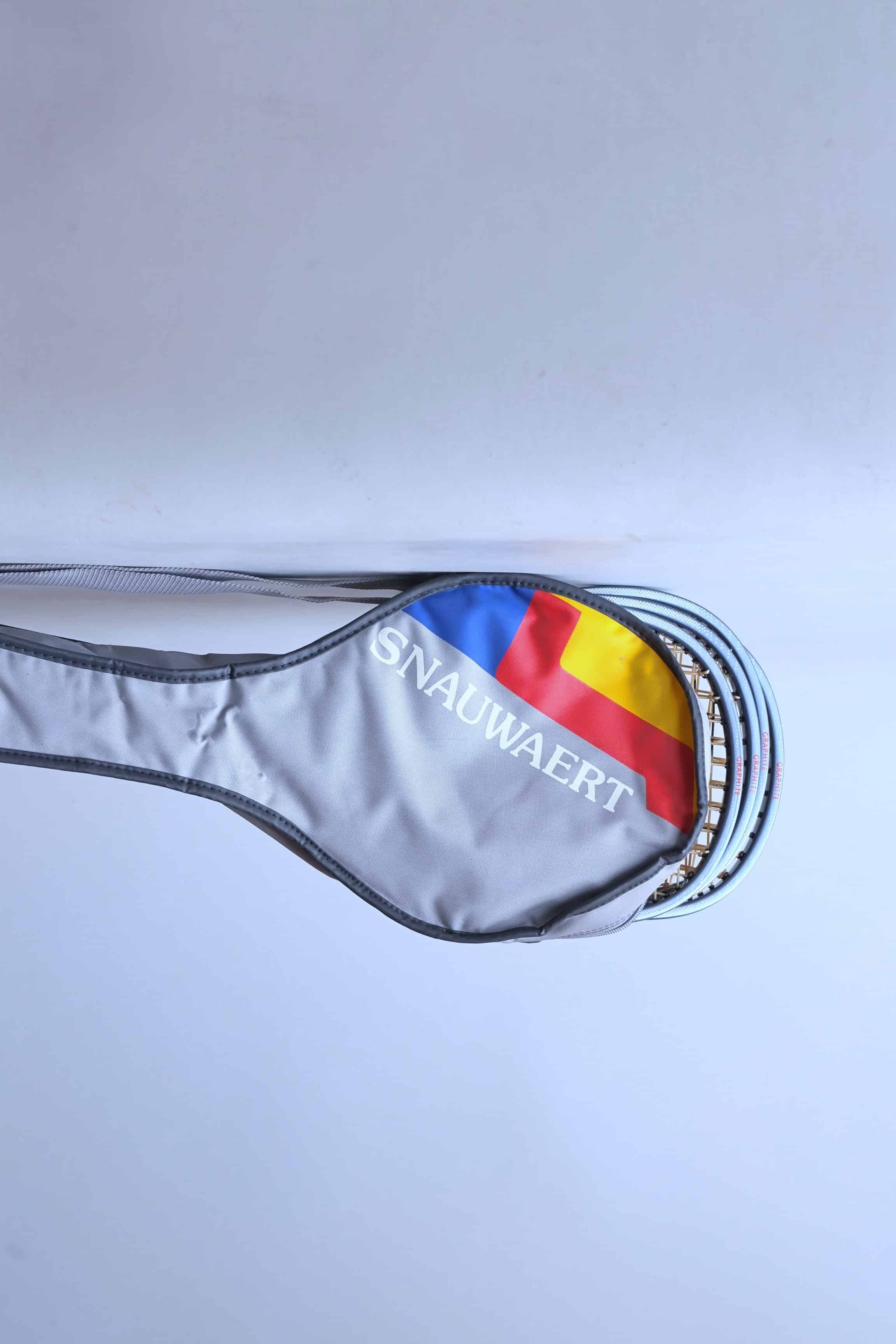 Close view of a vintage grey Snauwaert squash racket soft bag with a shoulder strap highlighting the red, yellow and blue brand logo.
