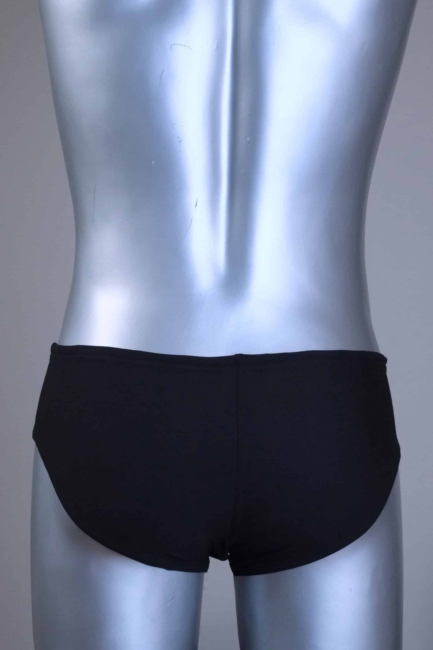 Back view of a pair of a Vintage Black men's swim briefs with white stripes on a metallic mannequin against a gray background