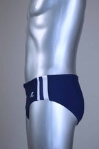 Side view of a pair of a Vintage navy men's swim briefs with white stripes on a metallic mannequin against a gray background