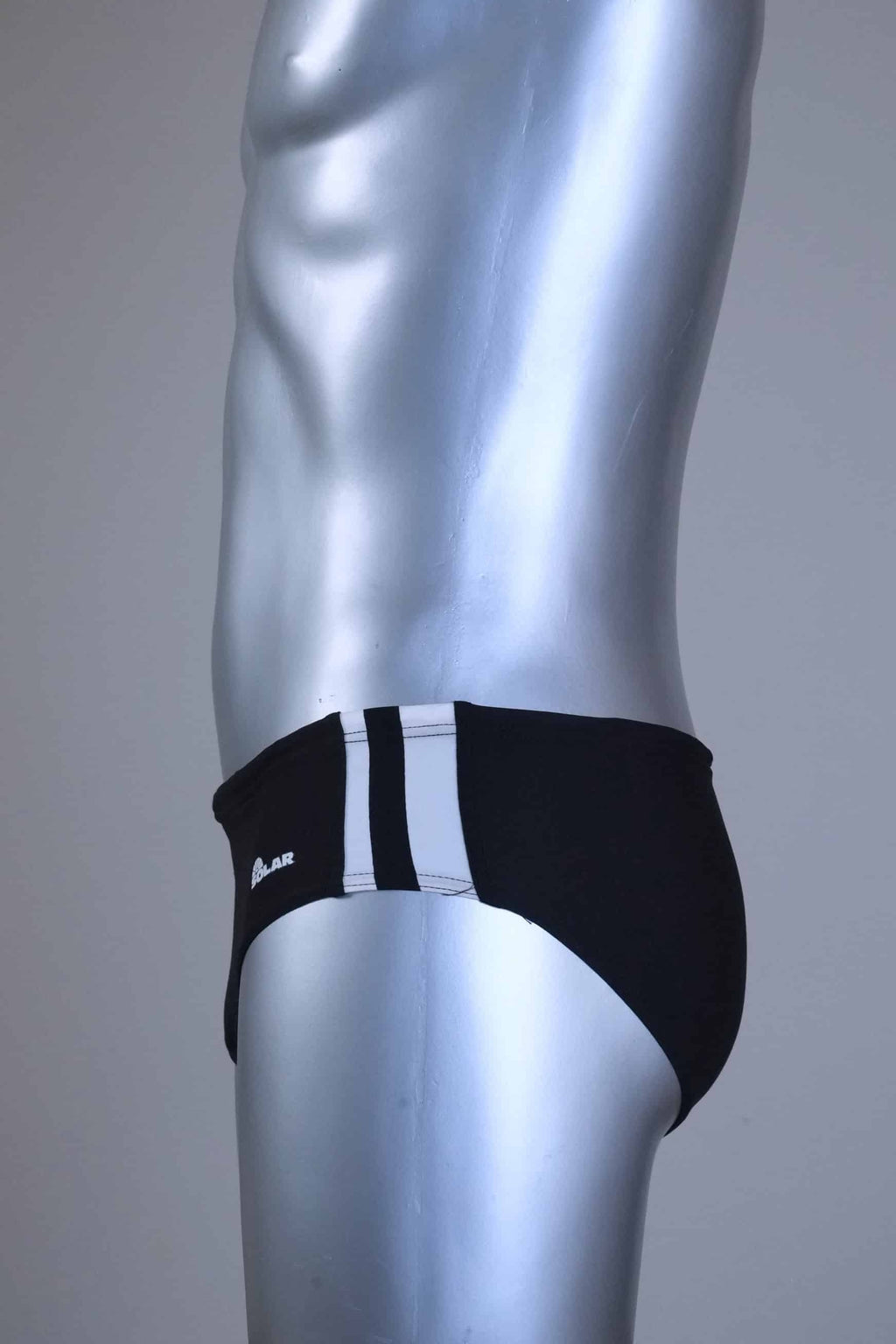 Side view of a pair of a Vintage Black men's swim briefs with white stripes on a metallic mannequin against a gray background