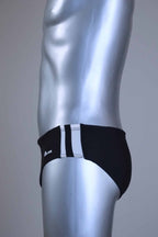 Side view of a pair of a Vintage Black men's swim briefs with white stripes on a metallic mannequin against a gray background
