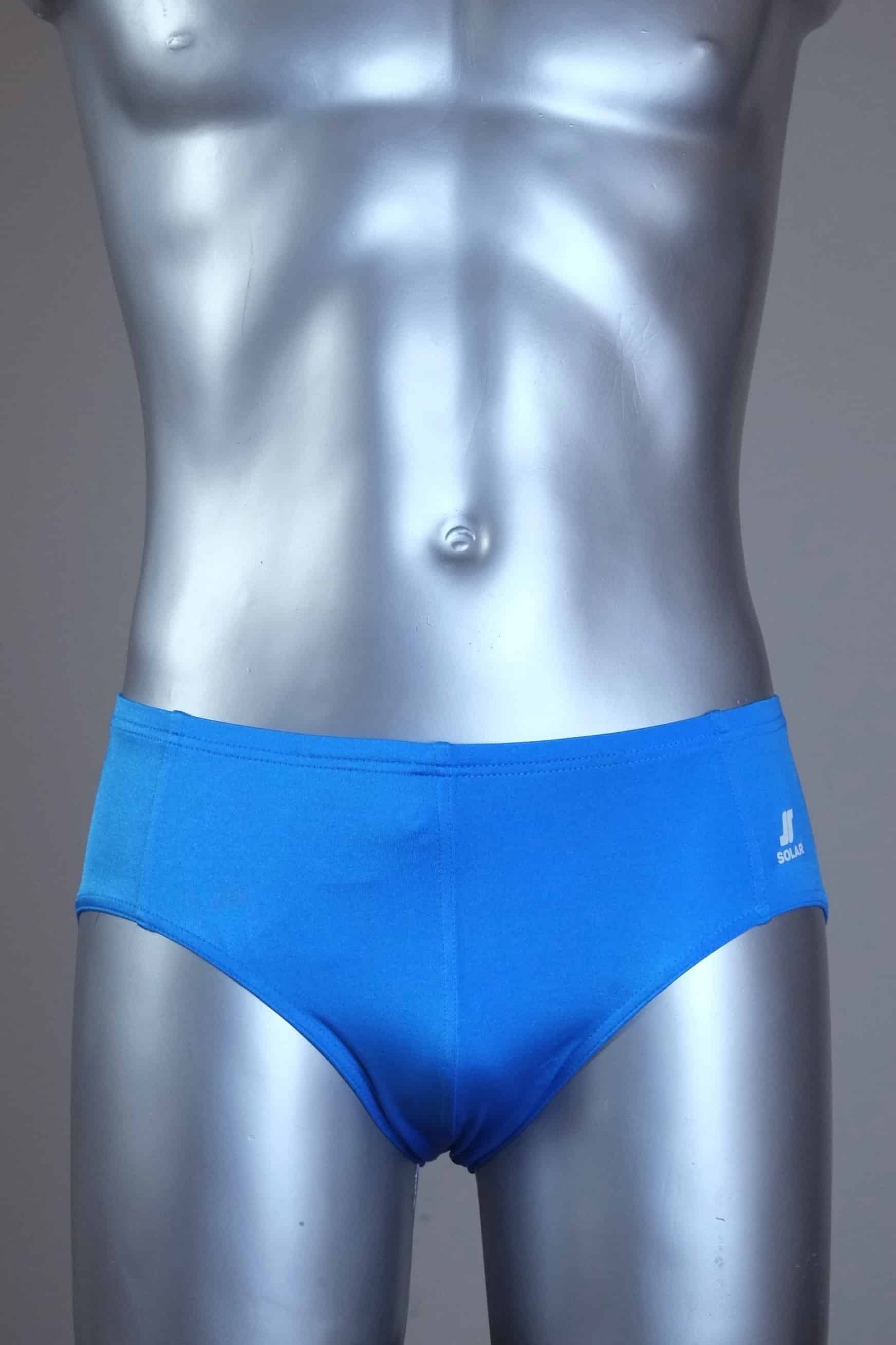 Mannequin wearing a pair of vintage 70s blue swim briefs with a visible brand logo on a gray background