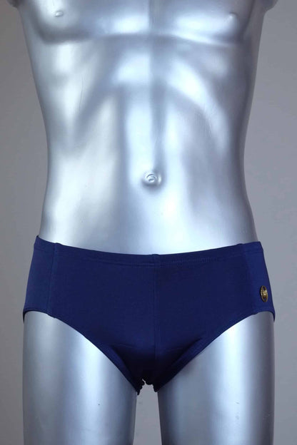 Mannequin wearing a pair of vintage 70s navy swim briefs with a visible brand logo on a gray background