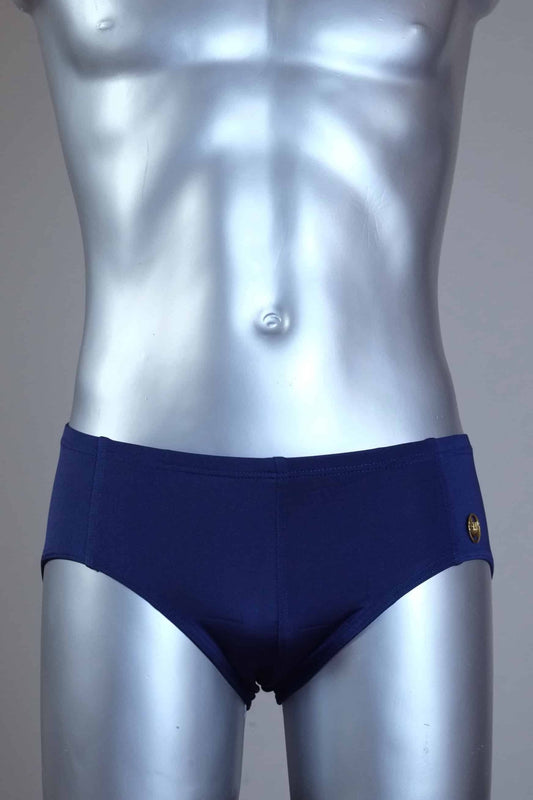 Mannequin wearing a pair of vintage 70s navy swim briefs with a visible brand logo on a gray background