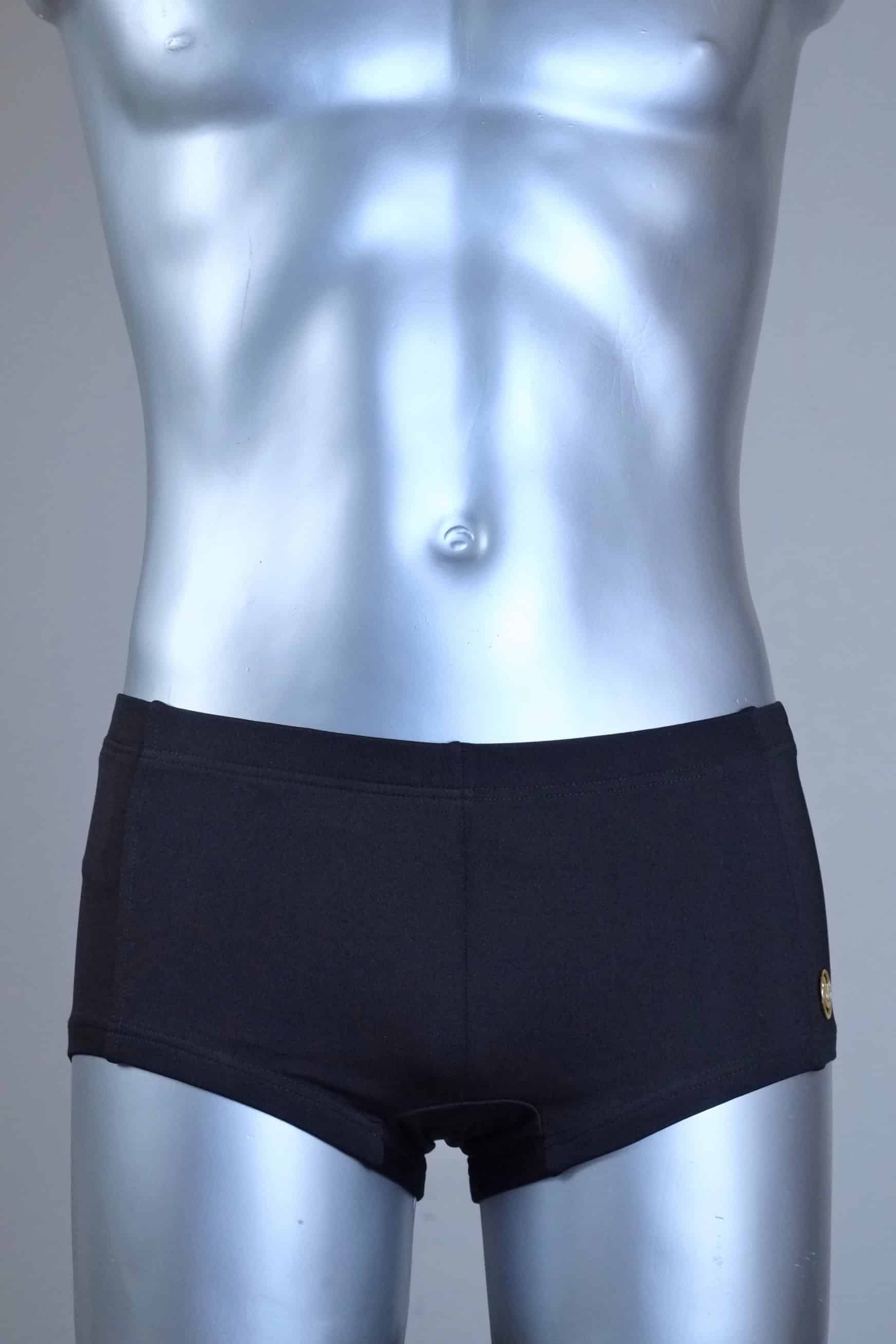 Mannequin wearing a pair of vintage 70s SOLAR swim trunks in black against a grey background.