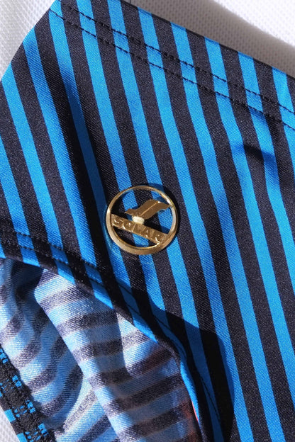 Close-up of a blue and black striped swim brief and a gold logo badge.