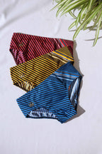 Three pairs of SOLAR brand vintage 80s men's swim briefs with horizontal and angled stripes in red, yellow, and blue, aid flat on a white background.