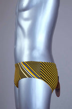 Side view of yellow striped men's Solar swim briefs on a silver mannequin against a gray background