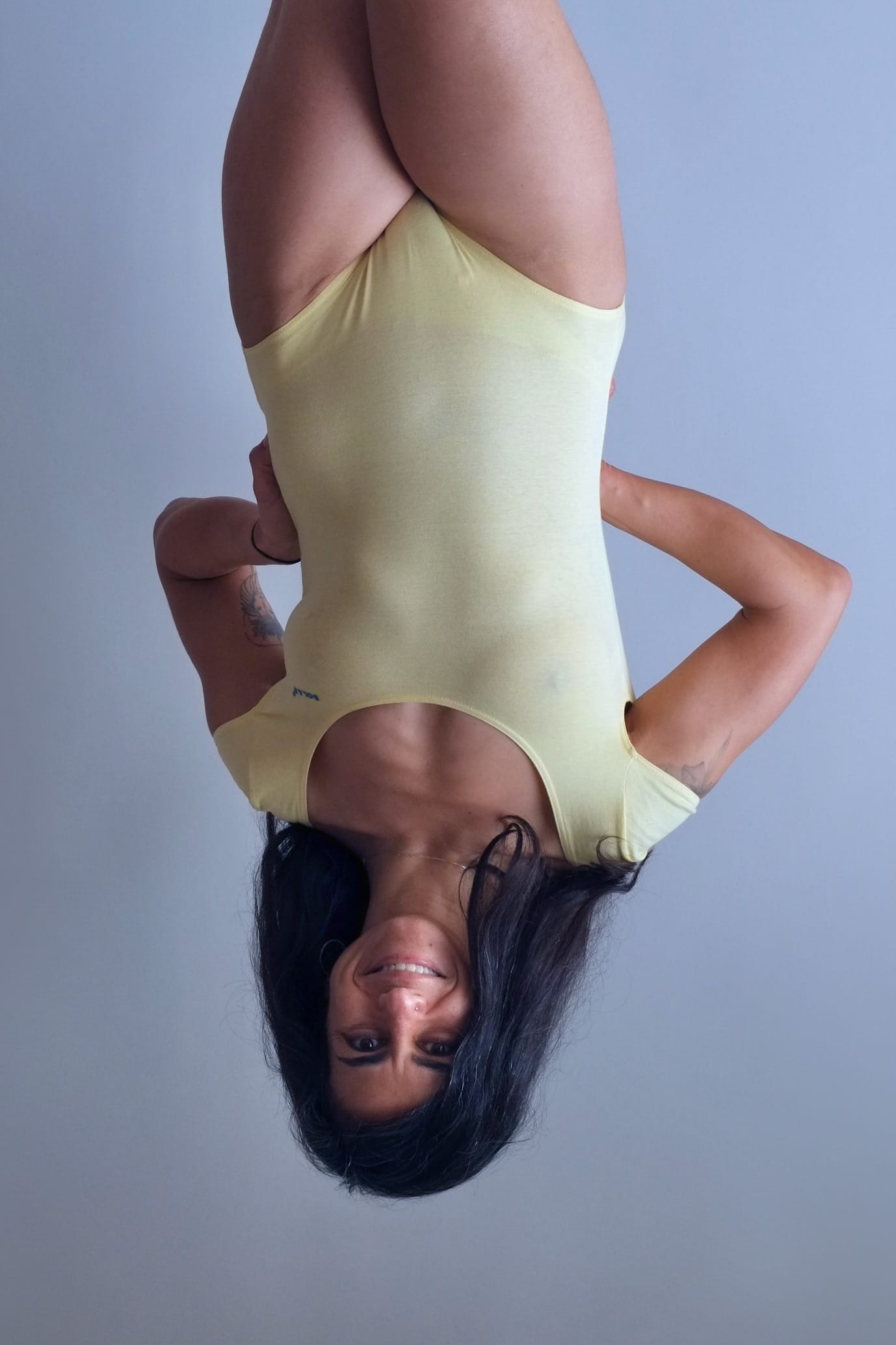 Solar vintage 80s solid pale yellow cap sleeve leotard worn on a female model — scoop neckline, short cap sleeves, high cut leg, front view