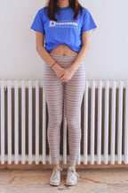 Solar vintage 80s micro stripe cotton leggings worn on a female model — fine pink and blue stripes on heather grey base, slim full-length cut, styled with white Converse sneakers and blue Converse t-shirt, front view