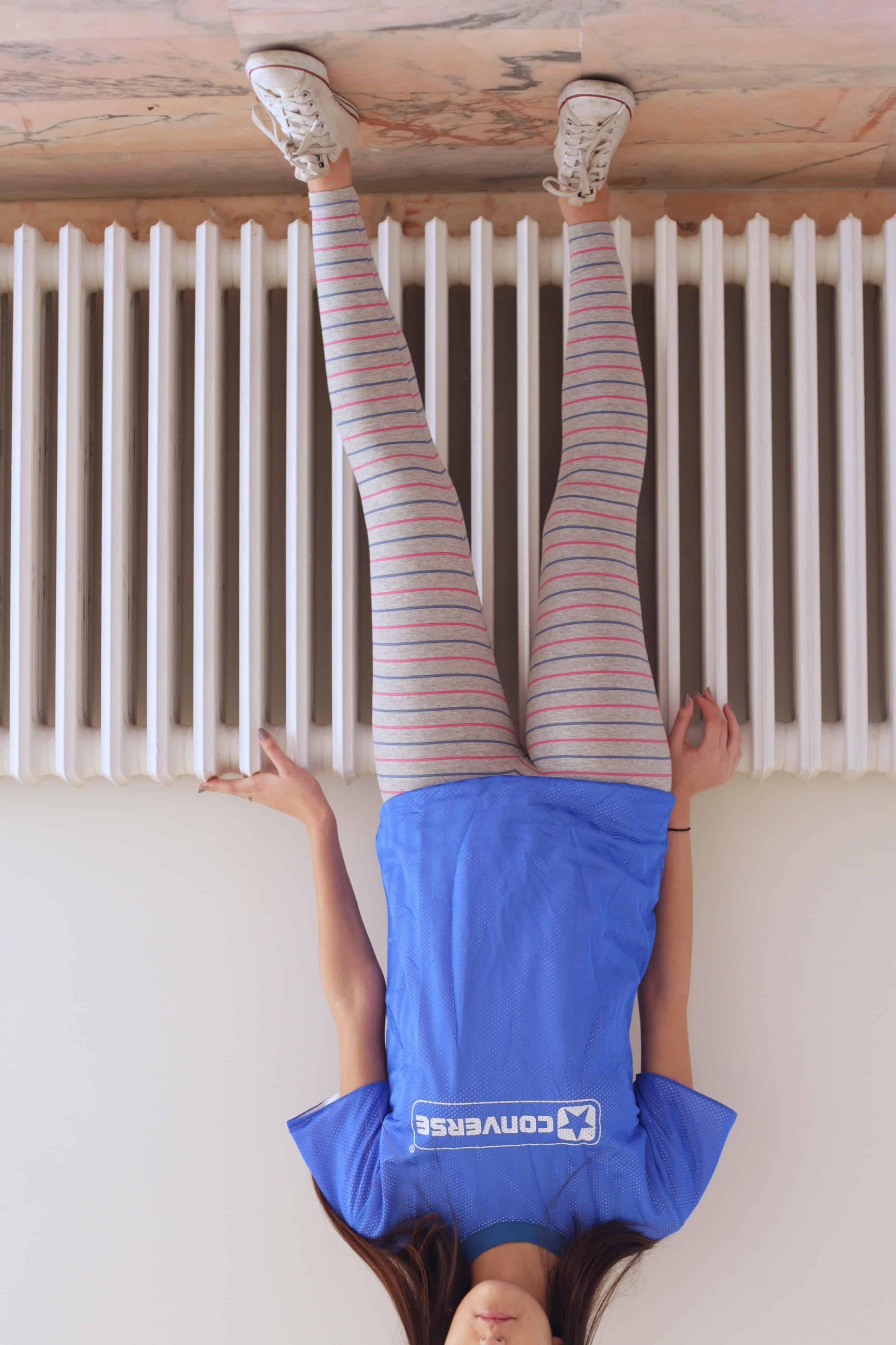 Solar vintage 80s micro stripe cotton leggings worn on a female model — fine pink and blue stripes on heather grey base, slim full-length cut, styled with white Converse sneakers and blue Converse t-shirt, relaxed standing pose, front view