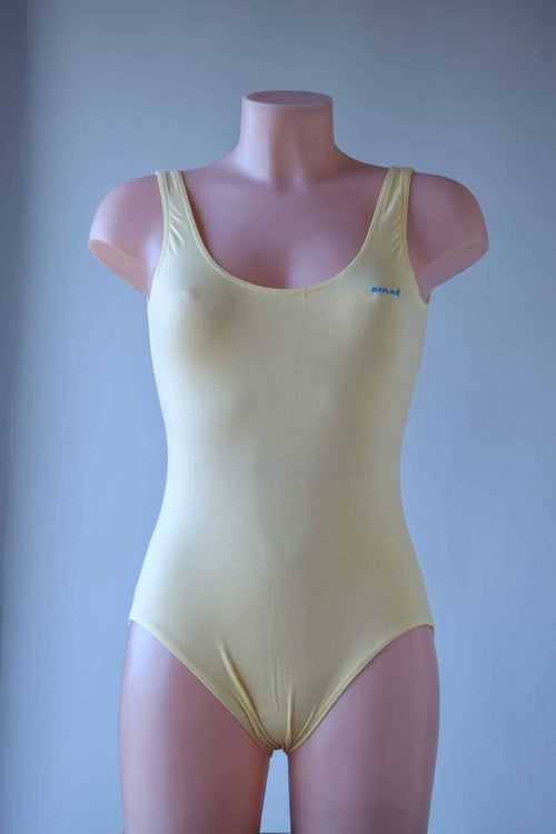 Front view of a solid pale yellow Solar leotard with wide tank straps and a high-cut leg.
