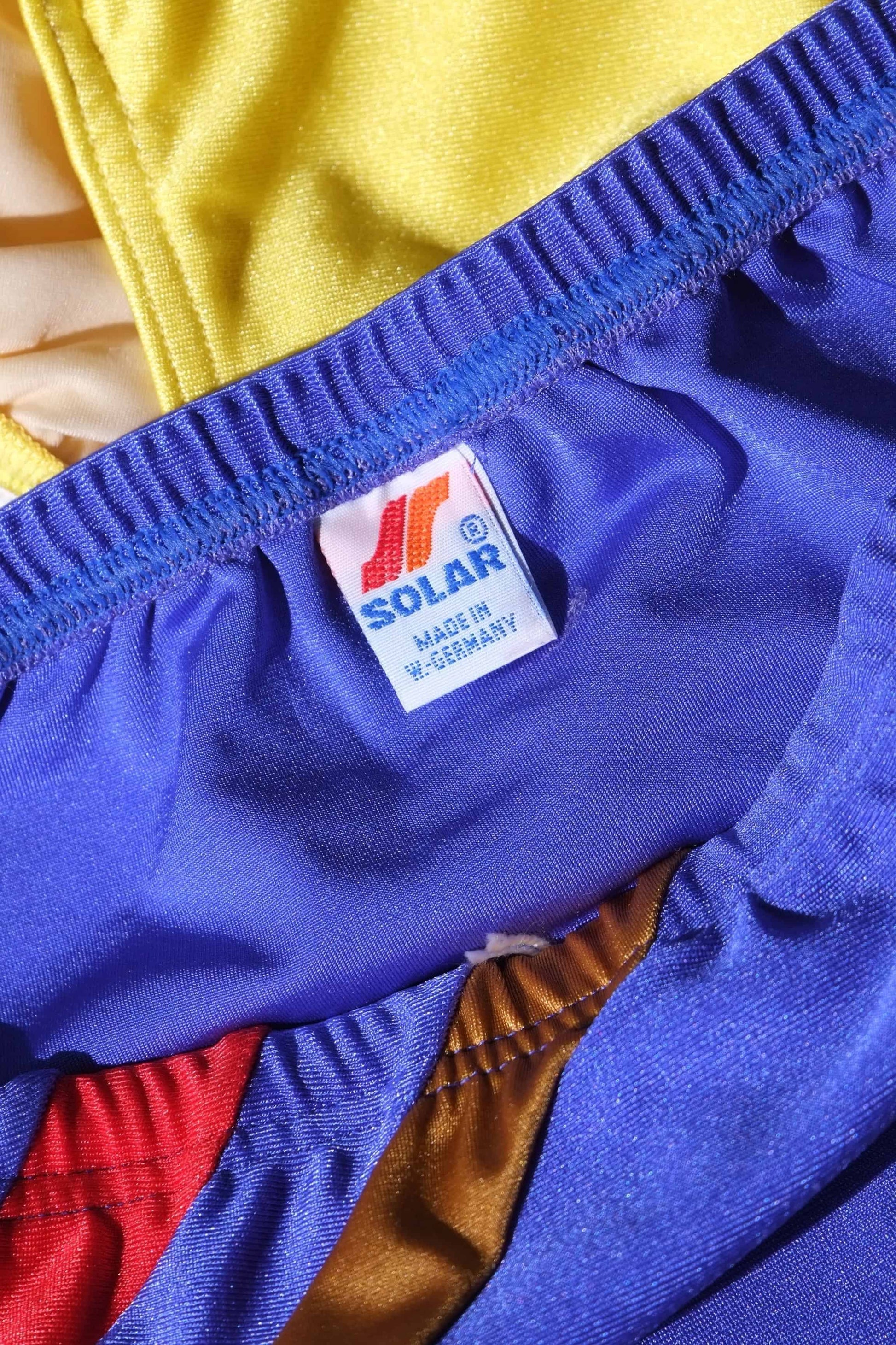 Close-up of a blue garment with a Solar label on a multicolored background