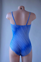 Solar vintage 80s diagonal stripe spaghetti strap leotard worn on a mannequin — blue and white diagonal cross stripes, straight bandeau neckline, spaghetti straps, high cut leg, back view
