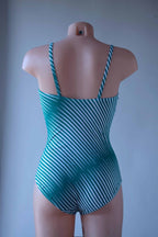 Solar vintage 80s diagonal stripe spaghetti strap leotard worn on a mannequin — green and white diagonal cross stripes, cross-back spaghetti straps, open back, high cut leg, rear view
