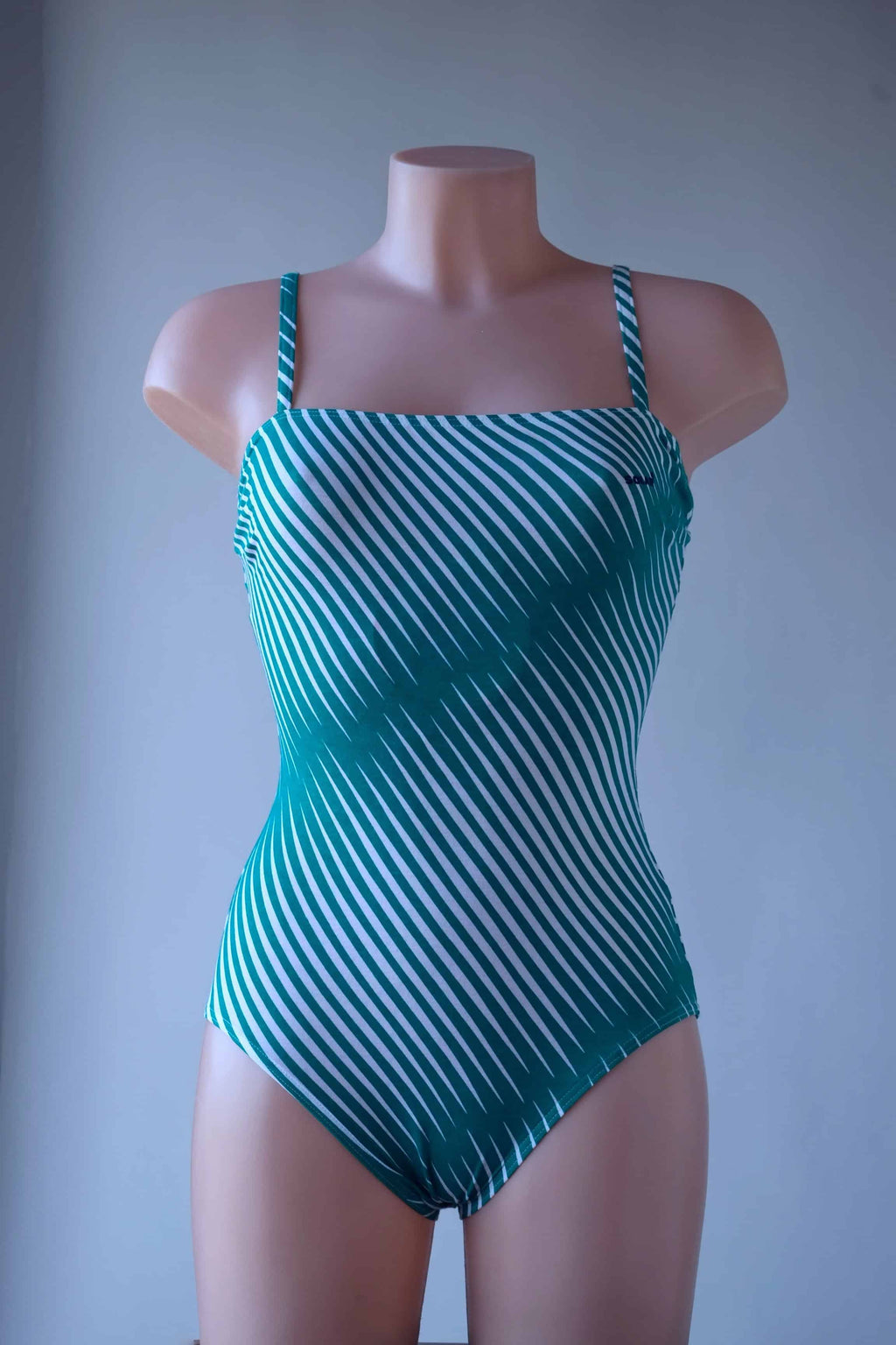 Solar vintage 80s diagonal stripe spaghetti strap leotard worn on a mannequin — green and white diagonal cross stripes, straight bandeau neckline, spaghetti straps, high cut leg, front view