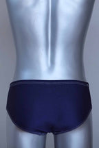Back view of a vintage navy men's swim briefs on a silver mannequin against a gray background