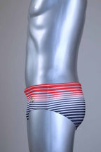 Side view of a Vintage 80s men's swim briefs featuring a red-to-black gradient horizontal stripe pattern on a silver mannequin