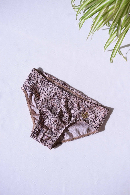 A single pair of SOLAR brand vintage 80s men's swim briefs with a light brown snakeskin print and a gold metal logo.