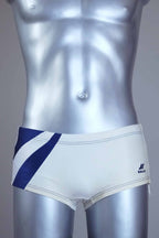Vintage white and navy swim briefs on a silver mannequin against a gray background