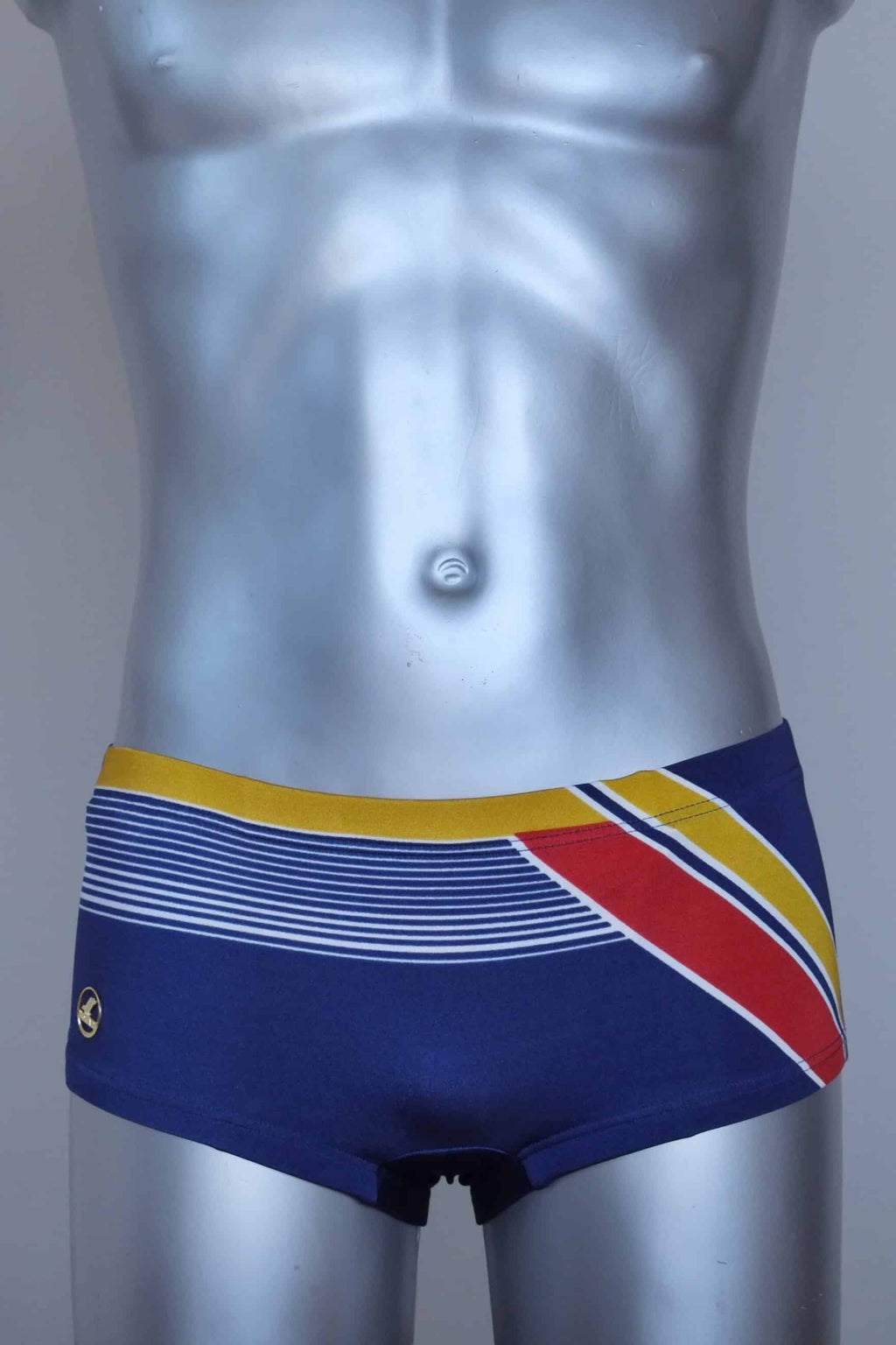 Vintage navy and red striped men's swim briefs on a silver mannequin against a gray background