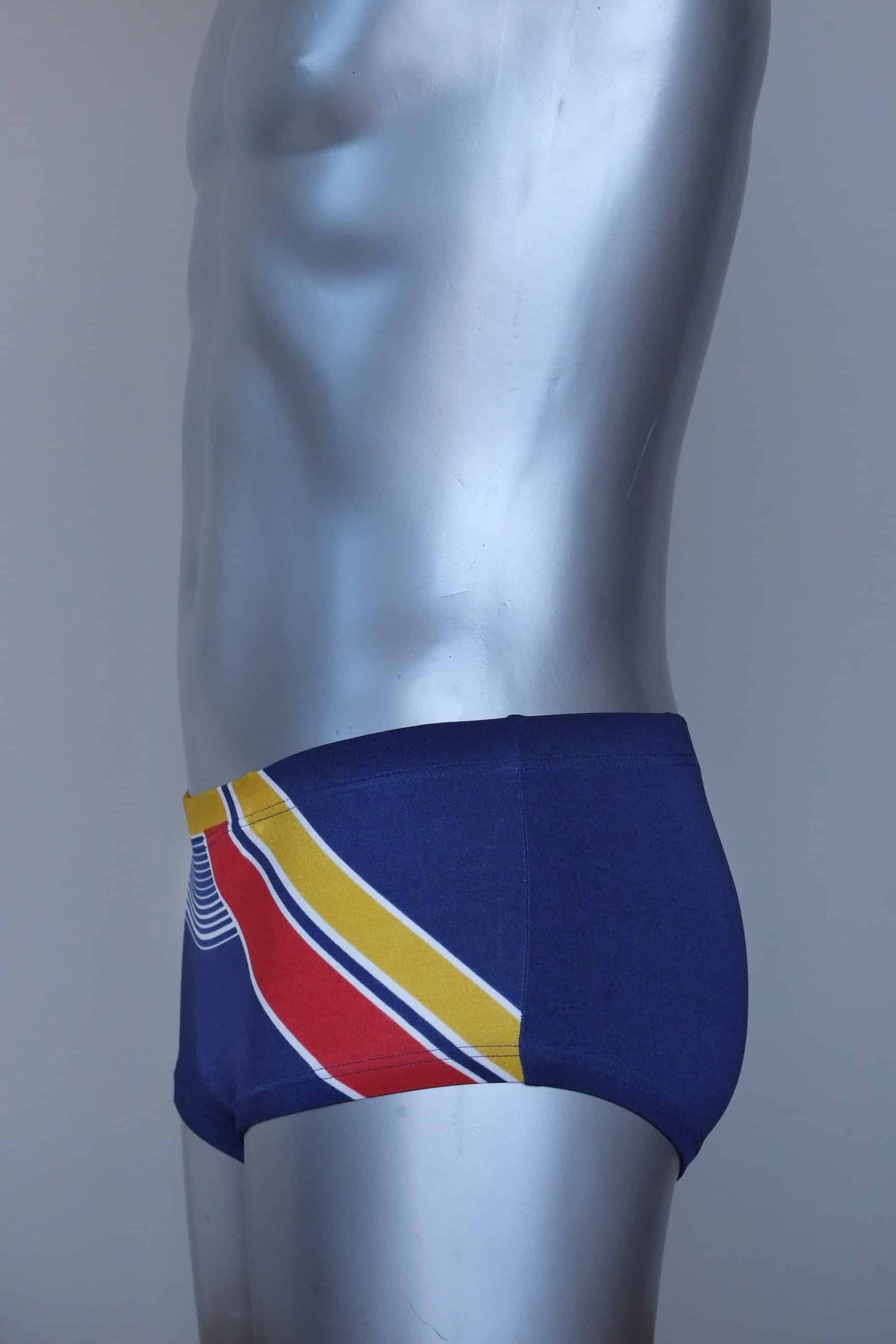Side view of a Vintage navy and yellow striped men's swim briefs on a silver mannequin against a gray background