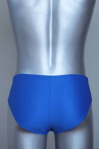 Back view of vintage blue swim briefs with mannequin against a gray background