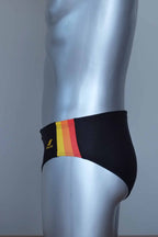 Side view of vintage black swim briefs with colorful side band on a mannequin against a gray background