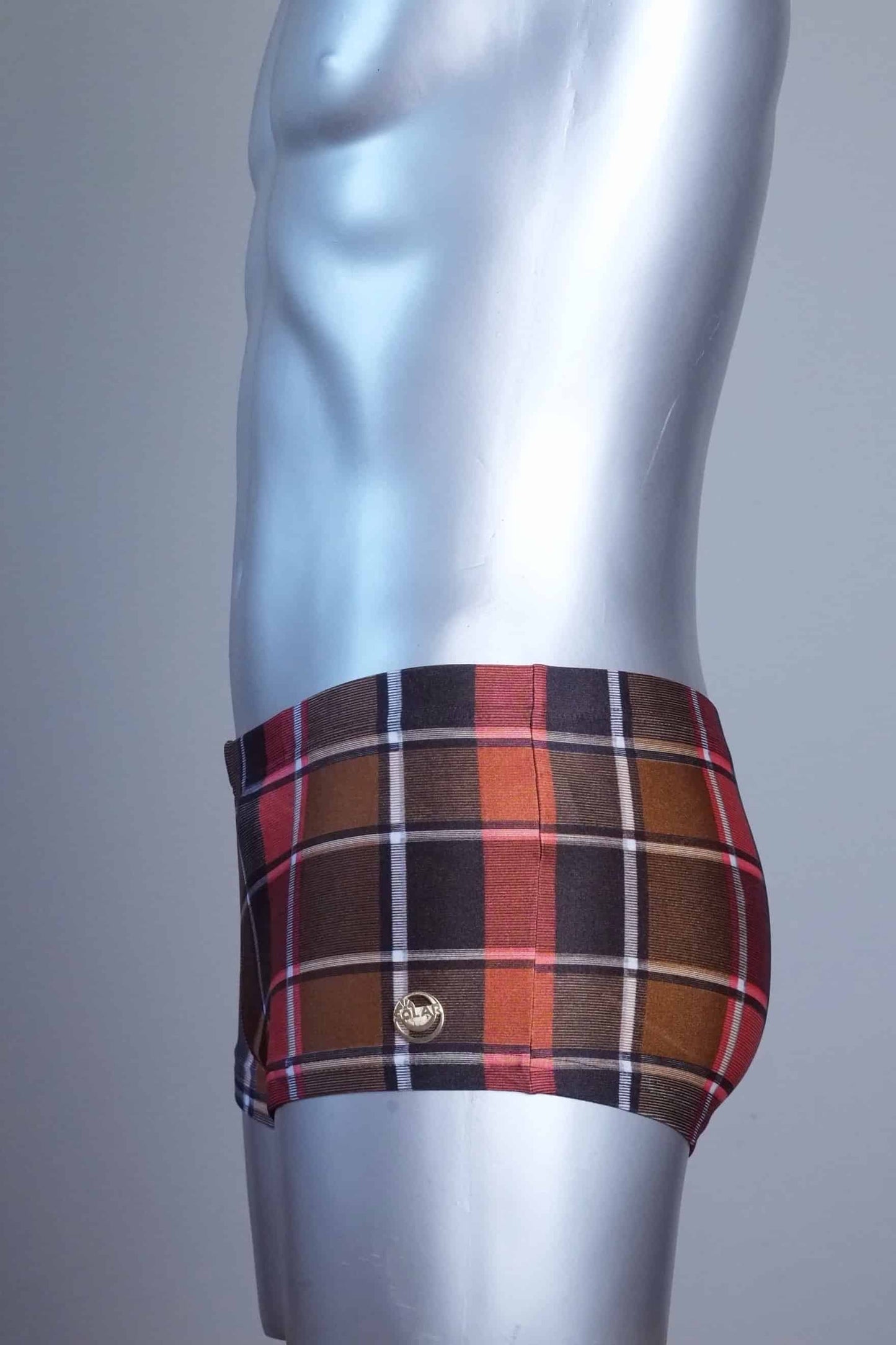 Side view of a Vintage brown plaid patterned swim briefs on a mannequin against a gray background