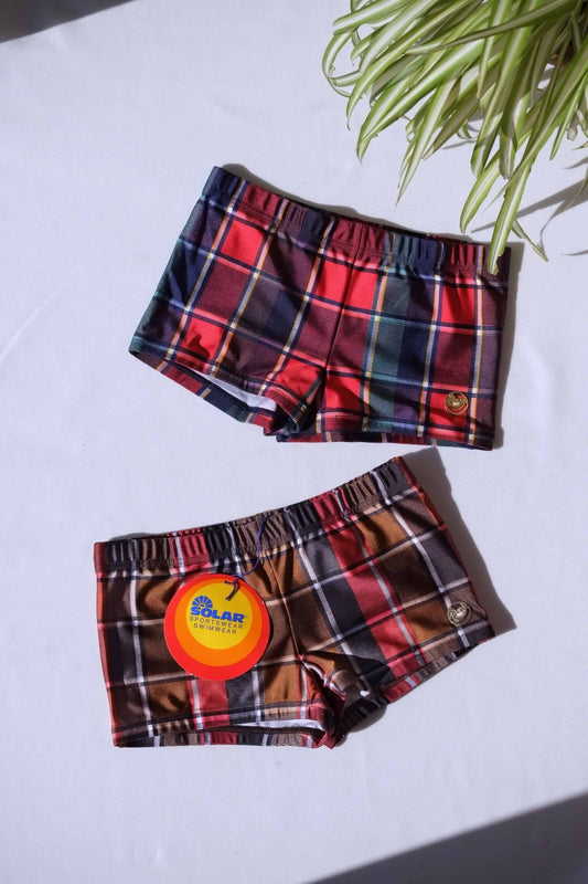 Two pairs of vintage 80s SOLAR swim briefs in red and brown plaid with metal logo badge.