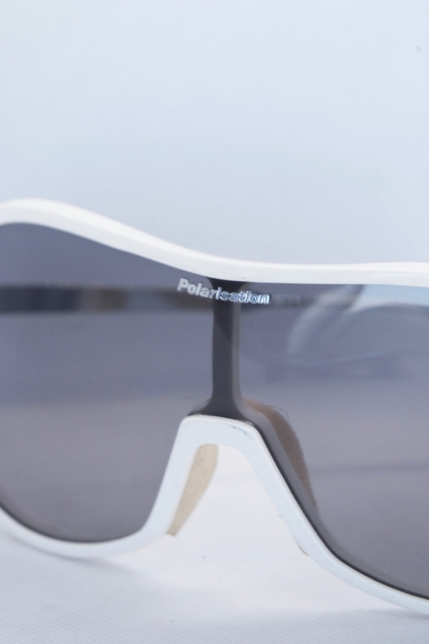 Close up of polarized lens of white sporteam vintage frames on white background